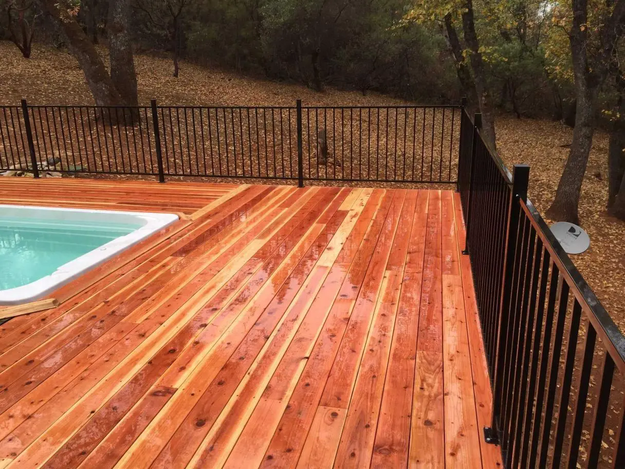 A wooden deck with a pool in the middle of it.