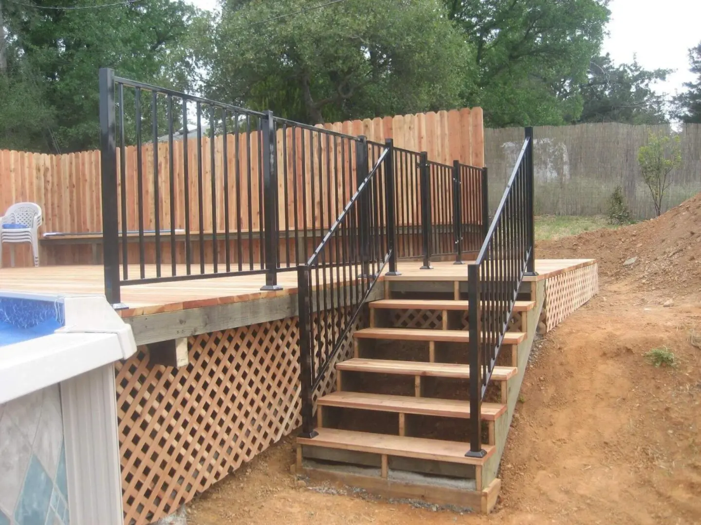 A wooden deck with steps and metal railing.