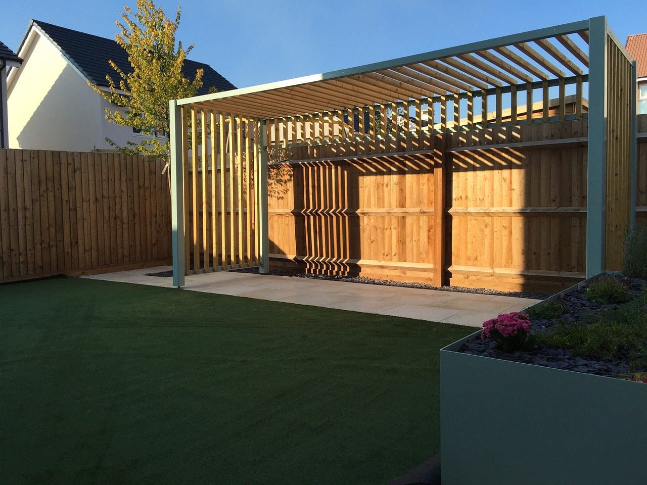 A wooden structure in the middle of a yard.